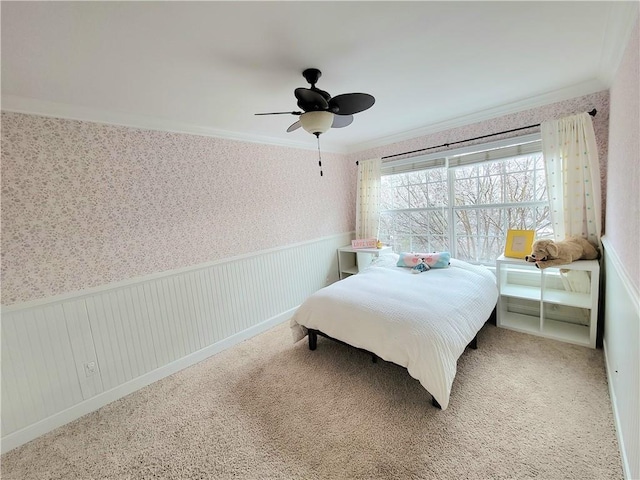 carpeted bedroom featuring ceiling fan and crown molding