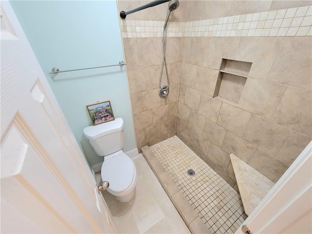 bathroom featuring toilet, tile patterned floors, and tiled shower