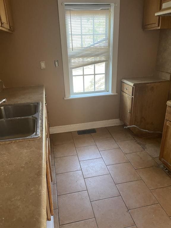 kitchen featuring sink and light tile patterned flooring