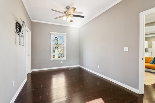 empty room featuring dark wood-type flooring, ornamental molding, and ceiling fan