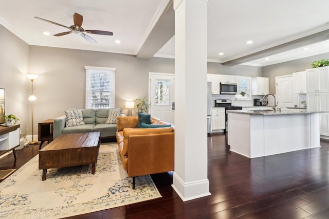 living room featuring beamed ceiling, ceiling fan, dark hardwood / wood-style floors, and ornate columns