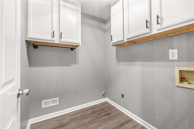 washroom featuring washer hookup, cabinets, electric dryer hookup, and hardwood / wood-style flooring