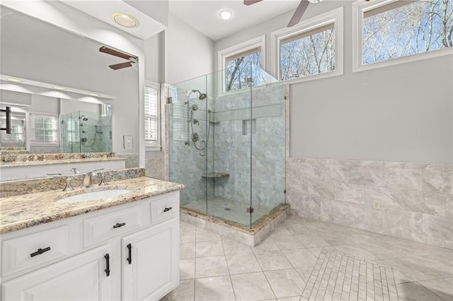 bathroom featuring ceiling fan, walk in shower, and vanity