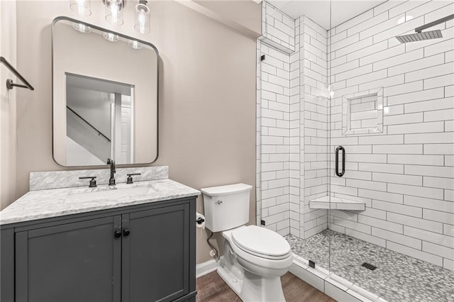 bathroom with toilet, a shower with door, vanity, and wood-type flooring