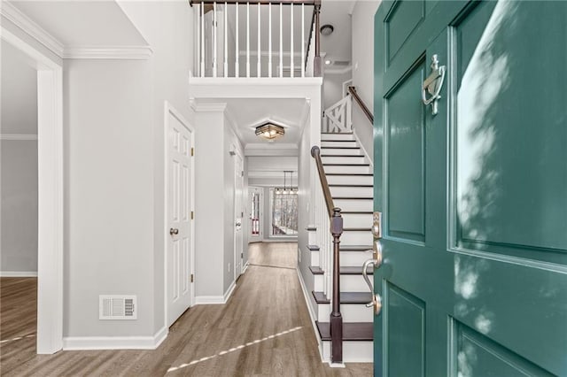 foyer featuring wood-type flooring and ornamental molding