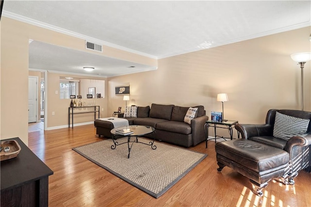 living room featuring crown molding and light hardwood / wood-style flooring