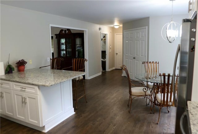 kitchen featuring white cabinetry, dark hardwood / wood-style floors, and stainless steel fridge