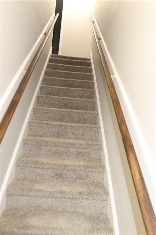 stairs featuring dark carpet