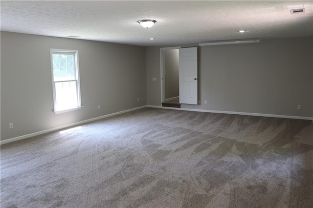 carpeted spare room with a textured ceiling