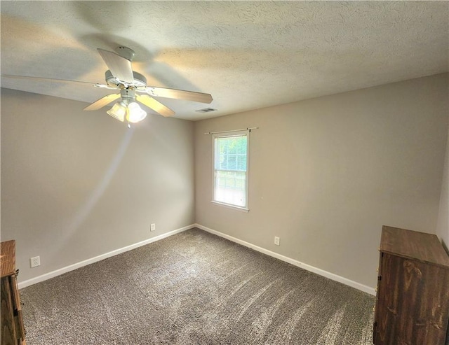 carpeted spare room featuring ceiling fan and a textured ceiling