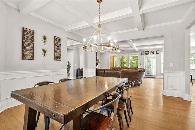 dining area with coffered ceiling, light wood-style floors, a chandelier, beam ceiling, and a decorative wall