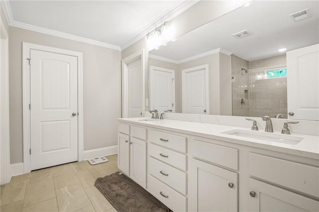 bathroom featuring a tile shower, baseboards, double vanity, and crown molding