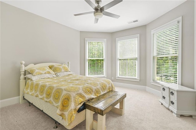 bedroom with light carpet, baseboards, and multiple windows