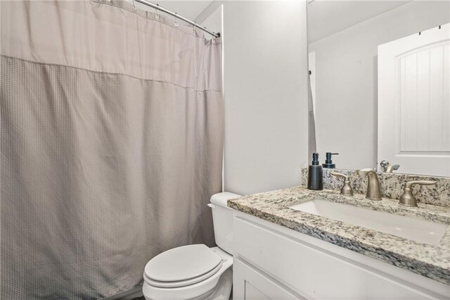 bathroom featuring toilet, vanity, and shower / bath combination with curtain