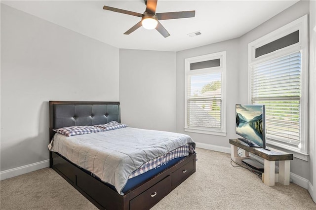 bedroom featuring baseboards, light colored carpet, and ceiling fan