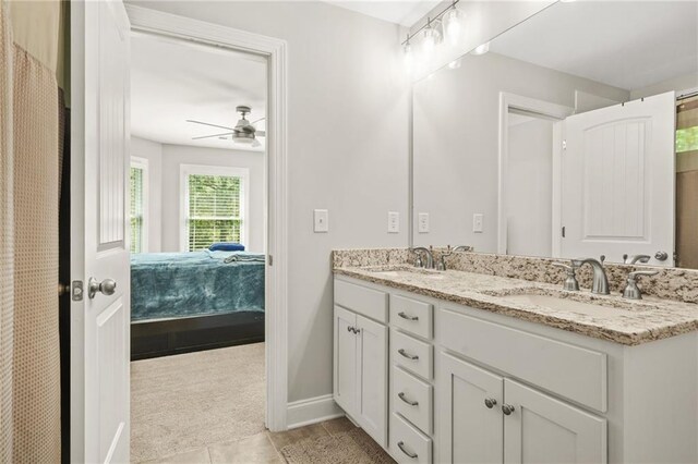 bathroom featuring connected bathroom, double vanity, ceiling fan, baseboards, and tile patterned floors