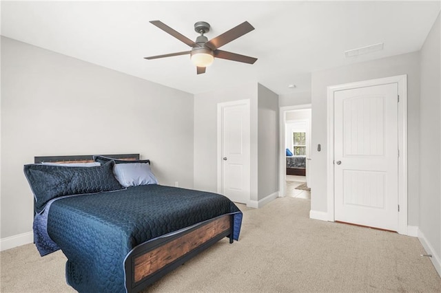 bedroom featuring light colored carpet, baseboards, and a ceiling fan