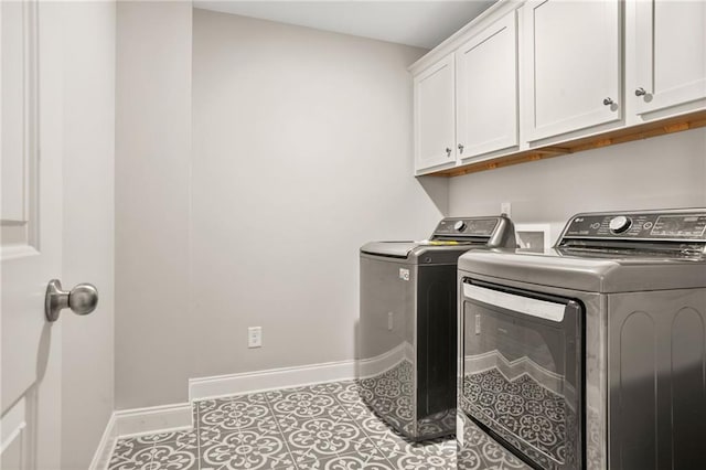 laundry room with cabinet space, washer and clothes dryer, baseboards, and tile patterned floors