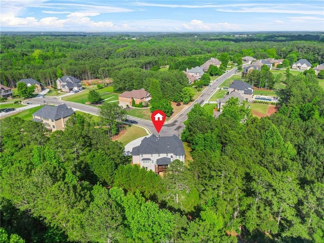 view of property location featuring a heavily wooded area and nearby suburban area