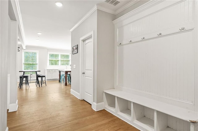 mudroom featuring crown molding, baseboards, and light wood-style flooring