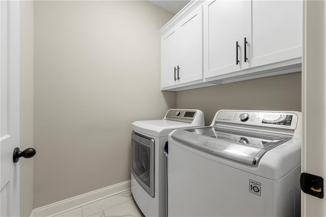 washroom featuring separate washer and dryer and cabinets