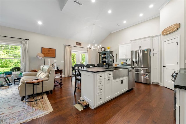 kitchen with white cabinetry, stainless steel appliances, plenty of natural light, and an island with sink