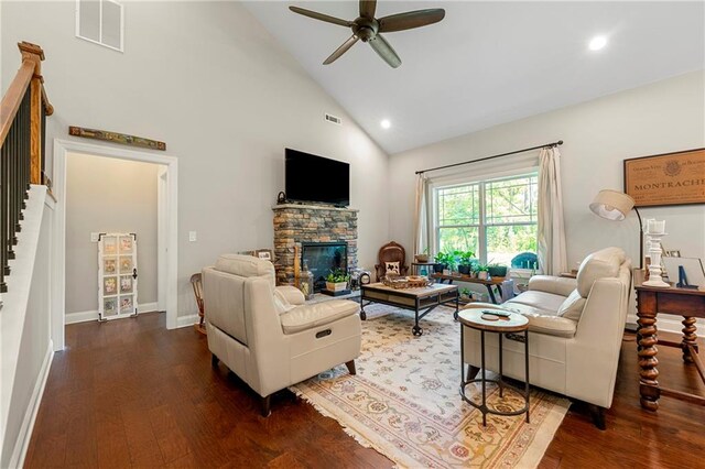 living room featuring a stone fireplace, high vaulted ceiling, dark hardwood / wood-style floors, and ceiling fan