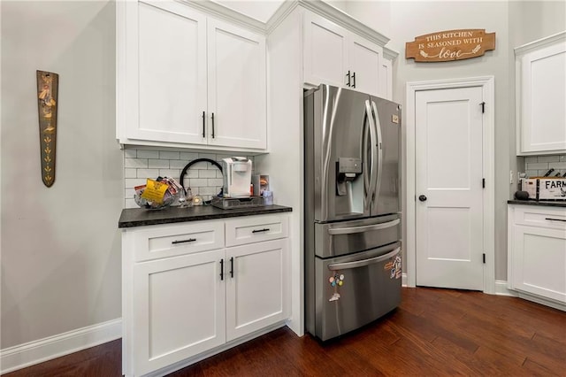 kitchen with white cabinets, stainless steel fridge with ice dispenser, dark hardwood / wood-style floors, and decorative backsplash