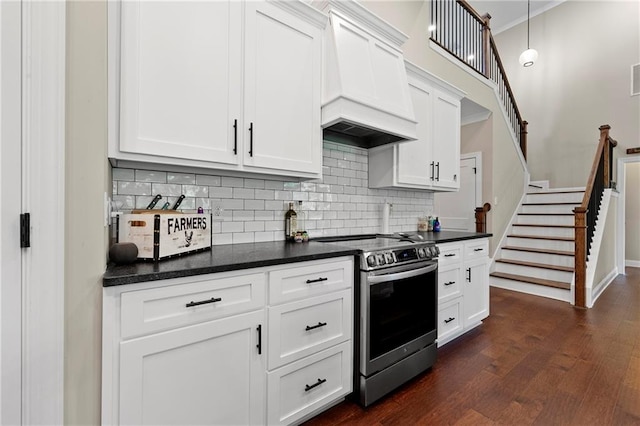 kitchen with stainless steel electric range, decorative light fixtures, white cabinets, dark wood-type flooring, and custom exhaust hood