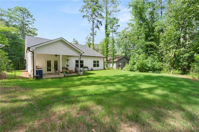 back of property featuring french doors, ceiling fan, a patio, and a yard