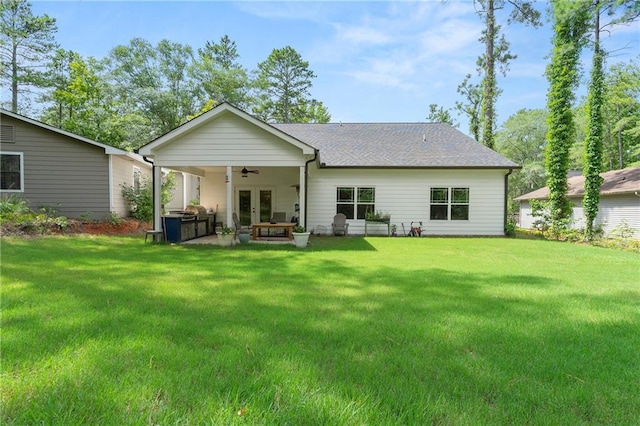 back of property featuring ceiling fan, a lawn, and a patio area