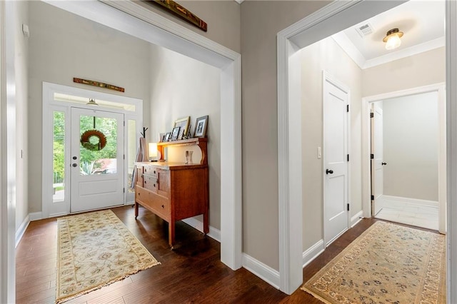 foyer entrance with dark hardwood / wood-style flooring and ornamental molding