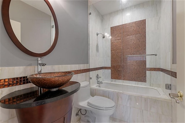 175 15th St NE Unit 410, Atlanta, GA 30309 - bathroom featuring tile walls, tiled shower / bath, toilet, a sink, and tile patterned flooring