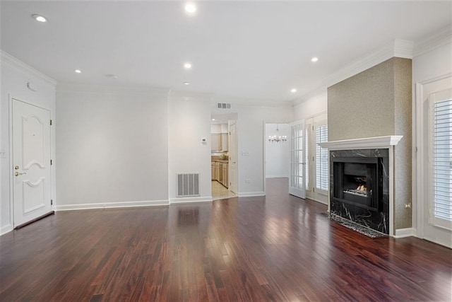 175 15th St NE Unit 410, Atlanta, GA 30309 - unfurnished living room featuring wood finished floors, a high end fireplace, ornamental molding, baseboards, and a chandelier