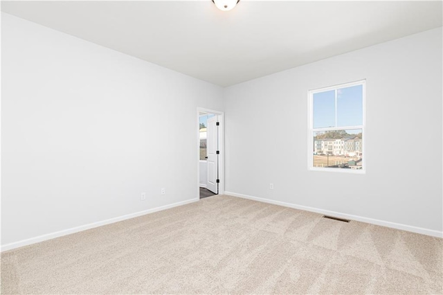 carpeted empty room with baseboards and visible vents