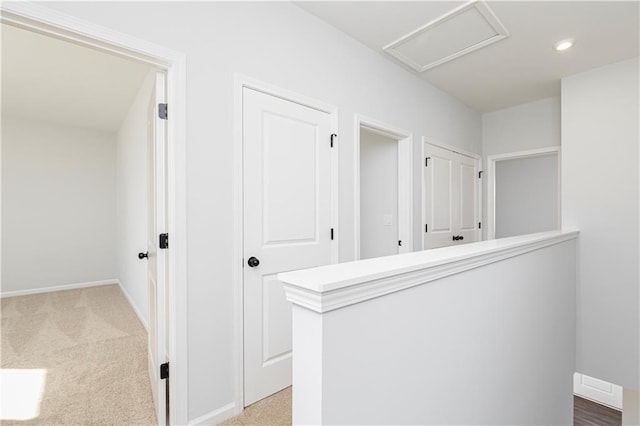 corridor with attic access, baseboards, recessed lighting, and carpet flooring