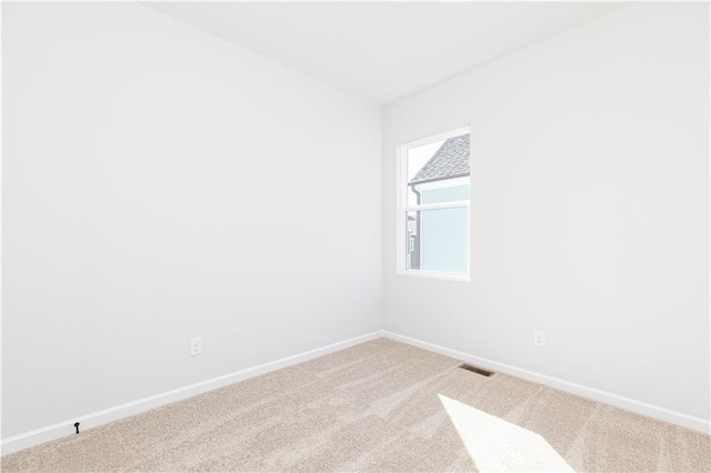 spare room with baseboards, carpet flooring, and visible vents