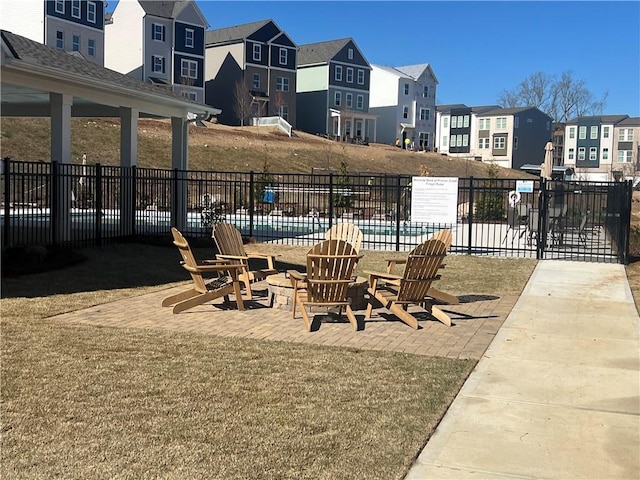 view of patio with a residential view, fence, and a pool