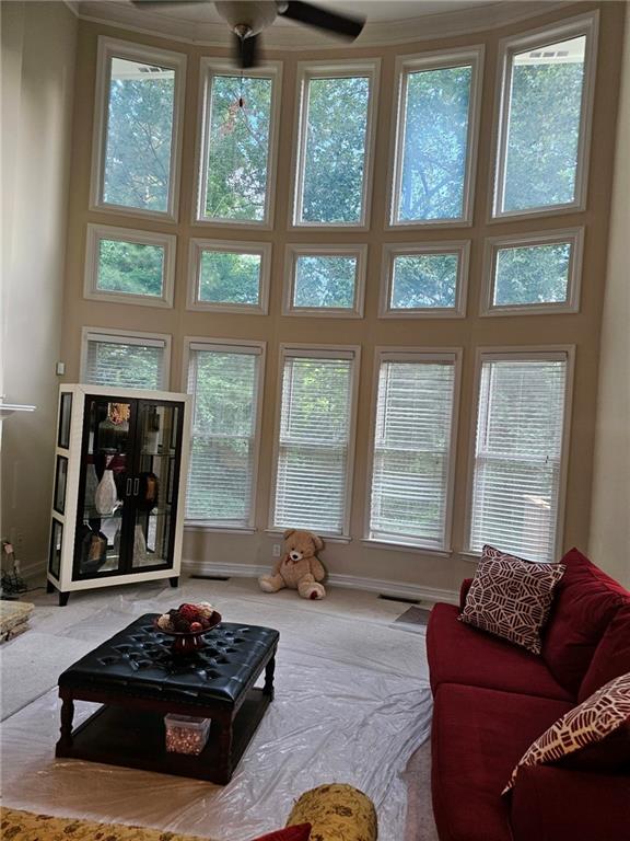 living room featuring ceiling fan and a towering ceiling