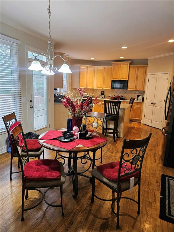 dining space featuring crown molding and hardwood / wood-style flooring