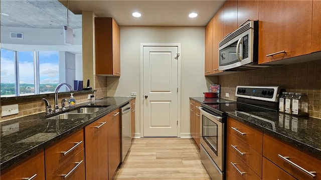 3300 Windy Ridge Parkway SE Unit 1121, Atlanta, GA 30339 - kitchen featuring stainless steel appliances, a sink, light wood-style floors, brown cabinetry, and recessed lighting