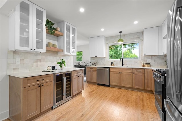 1494 May Ave SE, Atlanta, GA 30316 - kitchen featuring stainless steel appliances, wine cooler, a sink, light wood-style floors, and backsplash