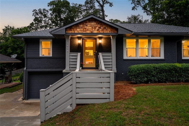1494 May Ave SE, Atlanta, GA 30316 - view of front of property featuring concrete driveway, brick siding, an attached garage, a yard, and roof with shingles