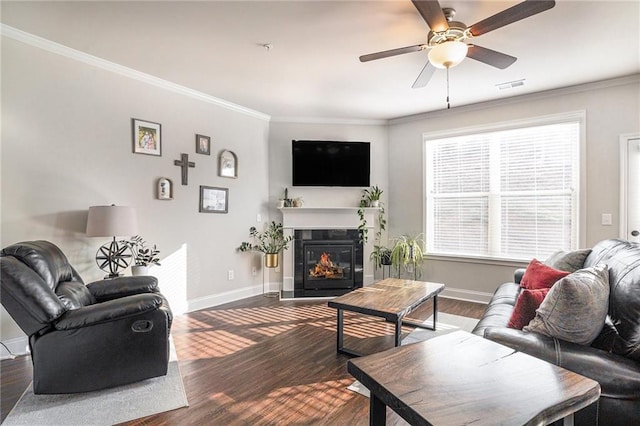 living room with dark wood-type flooring, ceiling fan, and ornamental molding