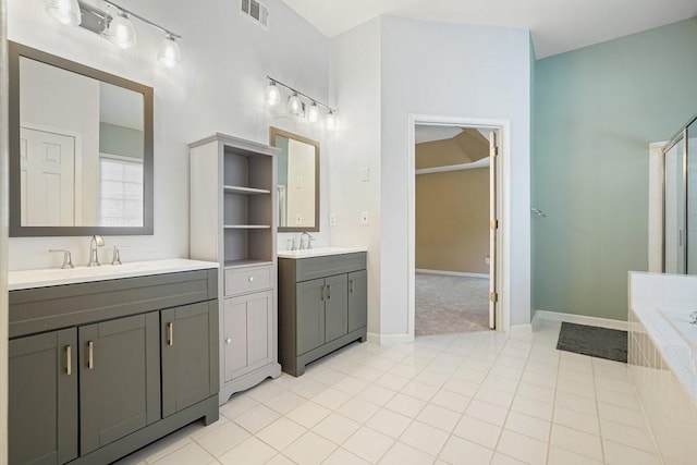 full bathroom featuring tile patterned flooring, two vanities, a sink, visible vents, and a bath