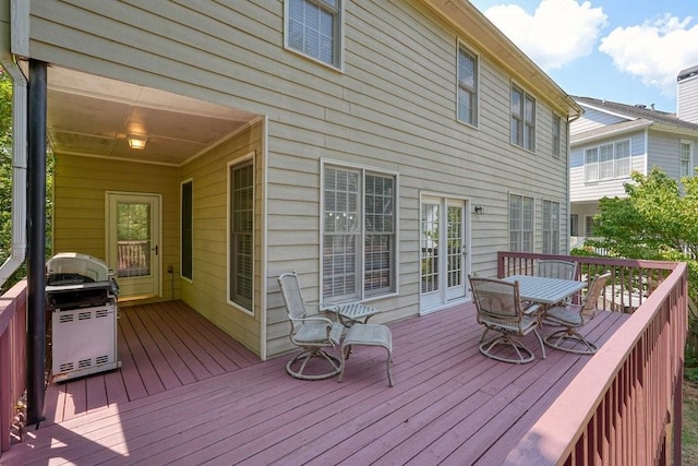 wooden terrace featuring outdoor dining area and a grill