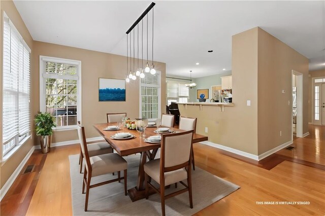 unfurnished dining area with baseboards, visible vents, and light wood-style floors