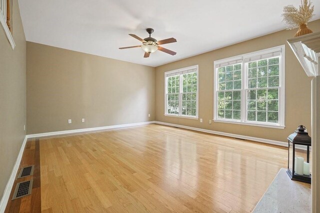 unfurnished living room with light wood-style flooring, baseboards, a ceiling fan, and a high end fireplace