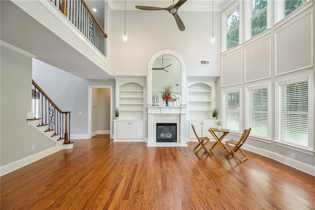 5635 Upper Creek Ct, Suwanee, GA 30024 - living area featuring a towering ceiling, ceiling fan, baseboards, built in features, and wood finished floors