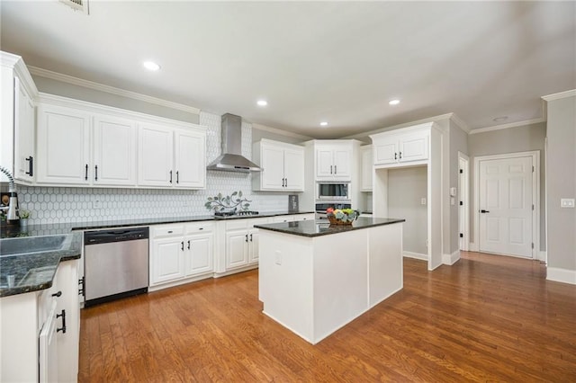 5635 Upper Creek Ct, Suwanee, GA 30024 - kitchen featuring appliances with stainless steel finishes, wall chimney range hood, crown molding, decorative backsplash, and white cabinets